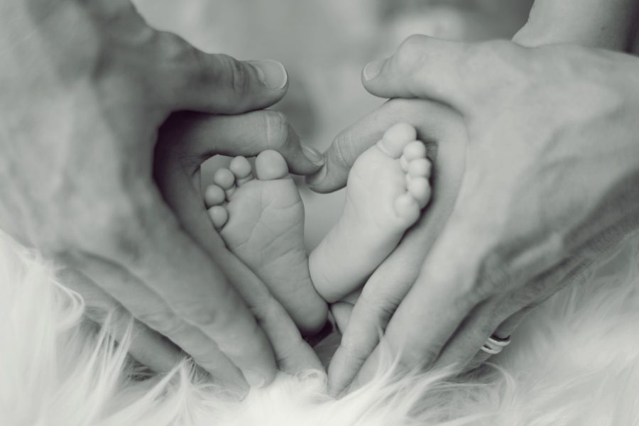 grayscale-photo-of-baby-feet-with-father-and-mother-hands-in-733881